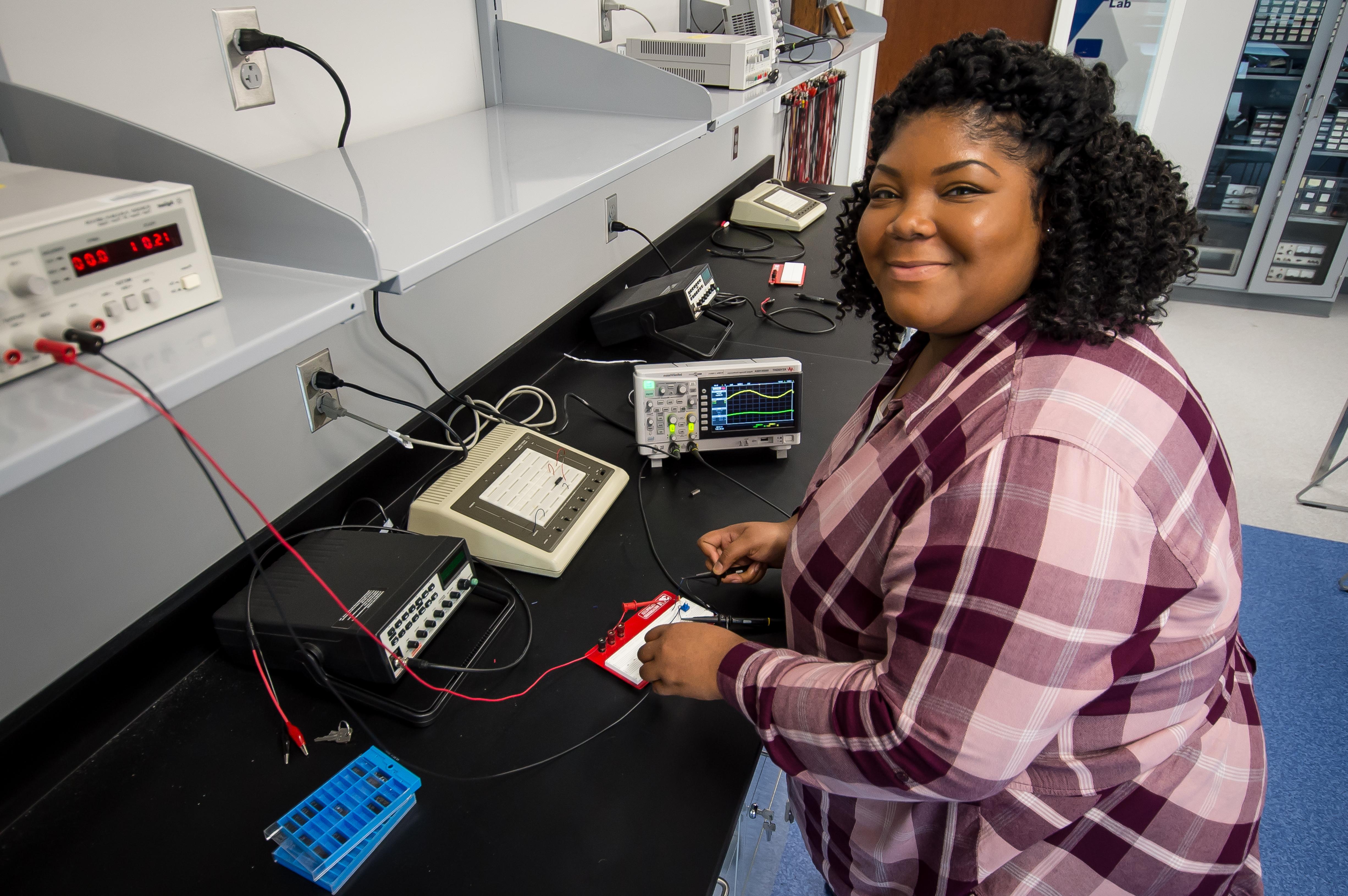 An engineering student connecting wires to a board